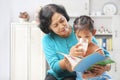 Grandma giving milk to her granddaugter Royalty Free Stock Photo