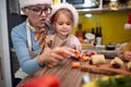 Grandma and granddaughter at the kitchen together preparing vegetables for a Xmas meal. Christmas, family, together Royalty Free Stock Photo