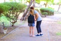 Grandma and granddaughter looking at homeless kitty in outdoor park. Royalty Free Stock Photo