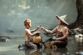 Grandma and grandson are holding crabs for food. After Grandma finishes rice farming