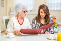 Grandma and her granddaughter looking at photo album together at home. Royalty Free Stock Photo