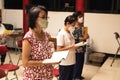 Grandma Holding a white book with Chinese text while reading it for praying