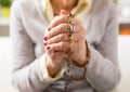 Grandma holding wooden rosary and praying Royalty Free Stock Photo