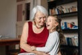 Grandma hugs her Sweet laughing granddaughter. It's nice and cozy at Grandma's house. Royalty Free Stock Photo