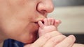 Grandma kisses tiny bare feet with little toes of baby Royalty Free Stock Photo