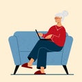 Grandma with Laptop sitting on the sofa at home.