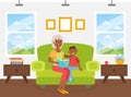 Grandma Reading Book to her Grandson Sitting on Sofa, Elderly Woman Spending Time at Home with her Grandchild, Boy Royalty Free Stock Photo