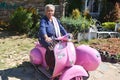 Grandma riding a small pink motorcycle