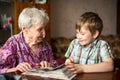 Grandma shows photo album to little grandson. Love. Royalty Free Stock Photo