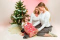 Grandmother with adult daughter and grandchild. under the christmas tree, opening presents Royalty Free Stock Photo
