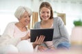 grandmother and adult granddaughter looking at tablet