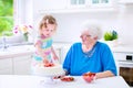 Grandmother baking cake with granddaughter