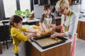Grandmother baking cookies with her grandchildren at home