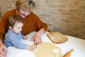 Grandmother baking tasty sweet cookies together with her grandda