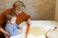 Grandmother baking tasty sweet cookies together with her grandda Royalty Free Stock Photo