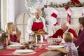 Grandmother Bringing Out Turkey At Family Christmas Meal