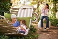 Grandmother, cat and children in a backyard, relax and bonding together with weekend break and happiness. Family, granny
