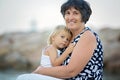 Grandmother and child, cute blond boy and young granny, hugging on the beach Royalty Free Stock Photo