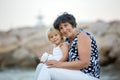 Grandmother and child, cute blond boy and young granny, hugging on the beach Royalty Free Stock Photo