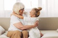 Grandmother child family sofa hugging love granddaughter happy girl home couch Royalty Free Stock Photo