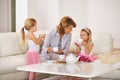 Grandmother, children and talking with tea cup in living room for bonding, playing and breakfast or brunch at home Royalty Free Stock Photo