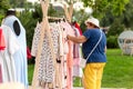 Grandmother chooses a stylish summer dress dress, which she will buy at the city fair