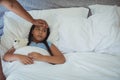 Grandmother comforting sick granddaughter in bed room Royalty Free Stock Photo