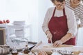 Grandmother concentrating on cutting dough