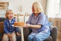 Grandmother cooking cake for grandson