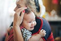 Grandmother cradling crying infant baby girl looking at camera Royalty Free Stock Photo