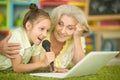 Grandmother and daughter singing karaoke with laptop