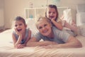Grandmother enjoying in bed with her little granddaughters. Royalty Free Stock Photo