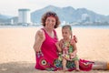 Grandmother enjoying day with granddaughter while blowing soap bubbles on the beach near the sea Royalty Free Stock Photo