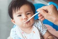 Grandmother feeding cute asian baby girl with a spoon Royalty Free Stock Photo