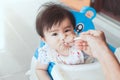 Grandmother feeding cute asian baby girl with a spoon Royalty Free Stock Photo