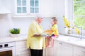 Grandmother and funny girl baking pie in white kitchen Royalty Free Stock Photo