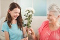 Grandmother giving a bunch of flowers to her granddaughter Royalty Free Stock Photo