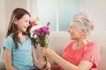 Grandmother giving a bunch of flowers to her granddaughter Royalty Free Stock Photo