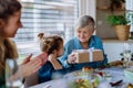 Grandmother giving gift to her granddaughter during Easter dinner. Royalty Free Stock Photo