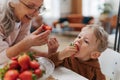 Grandmother giving homegrown strawberries to her little grandson.