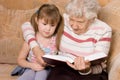 Grandmother with the grand daughter read the book