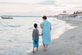 Grandmother with grandchild are resting on sea, running on beach having fun at summer holiday Royalty Free Stock Photo