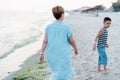 Grandmother with grandchild are resting on sea, running on beach having fun at summer holiday Royalty Free Stock Photo