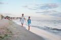 Grandmother with grandchild are resting on sea, running on beach having fun at summer holiday