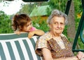 Grandmother with grandchild - senior woman looking at her granddaughter outdoor in nature
