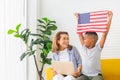 Grandmother and grandchildren playing cheerfully in living room, Woman with laptop and boy holding USA flag Royalty Free Stock Photo