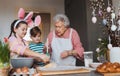 Grandmother with grandchildren preparing traditional easter meals, kneading dough for easter cross buns. Passing down Royalty Free Stock Photo