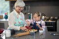 Grandmother and granddaughter adding strawberries to the crust