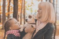 Grandmother with granddaughter in autumn park, girl hugging grandmother and her jack russell terrier dog. Generations Royalty Free Stock Photo