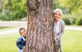 Grandmother and granddaughter behind tree at park Royalty Free Stock Photo